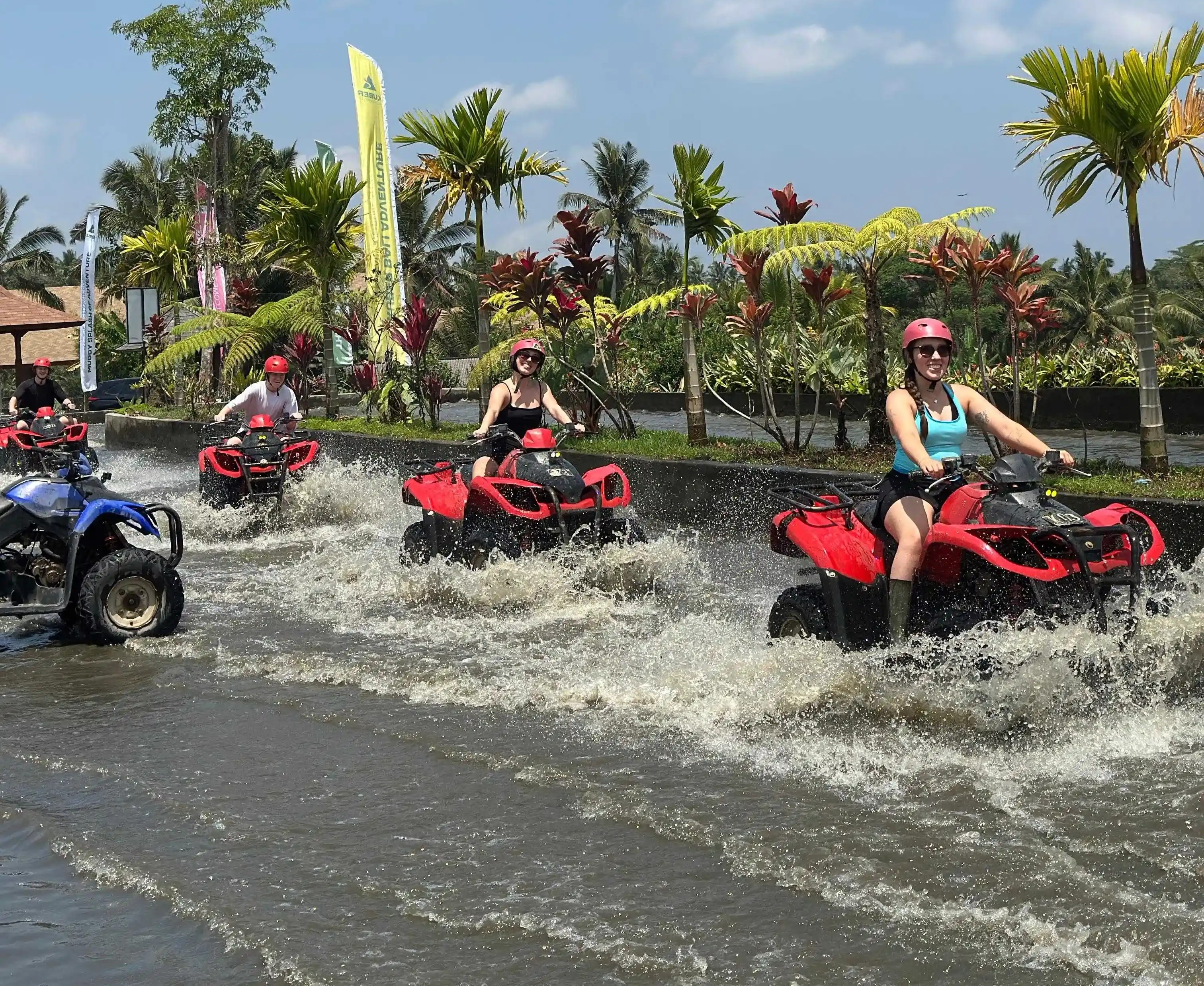Group of friends riding ATV quad bikes through muddy jungle trails in Ubud Bali
